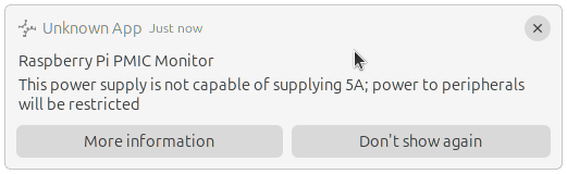 A desktop notification from the "Raspberry Pi PMIC Monitor" indicating "This power supply is not capable of supplying 5A; power to peripherals will be restricted". Beneath the warning are two action buttons: "More information", and "Don't show again"